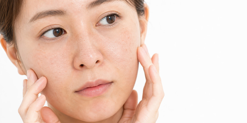 毛穴やくすみの悩みを確認する女性